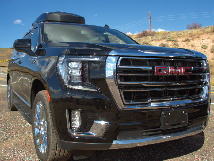 Black Diamond Cars GMC Yukon XL Denali on a Colorado mountain road near Vail